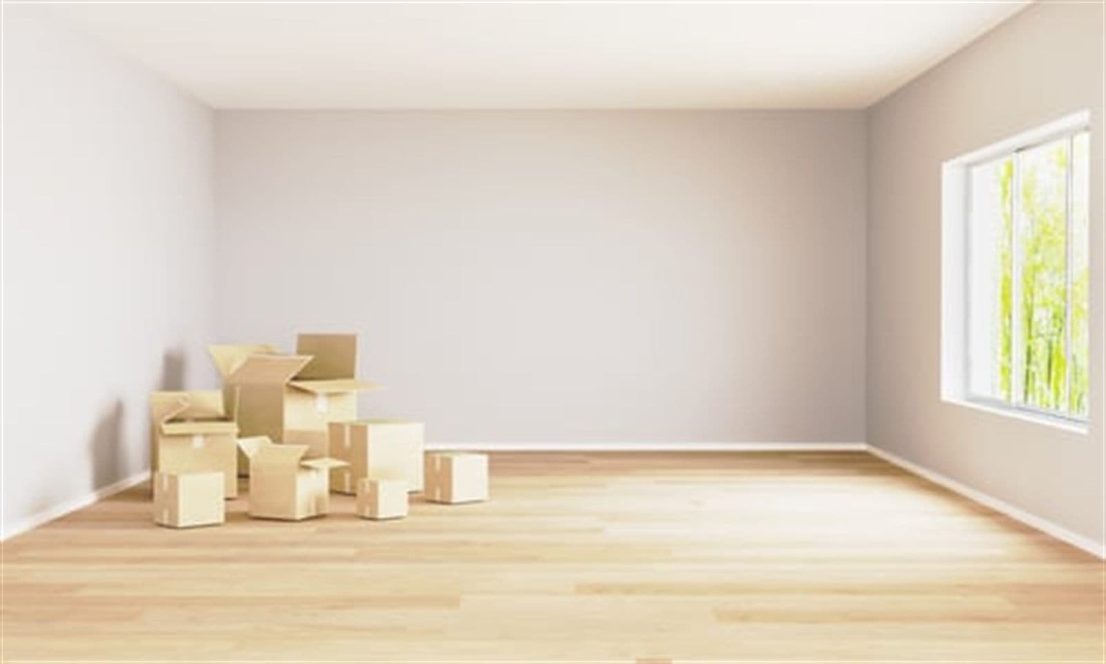 Cardboard moving boxes stacked in an empty room with hardwood floors before moving day